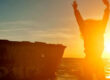 A person jumping for joy in the sunrise - enjoy the journey